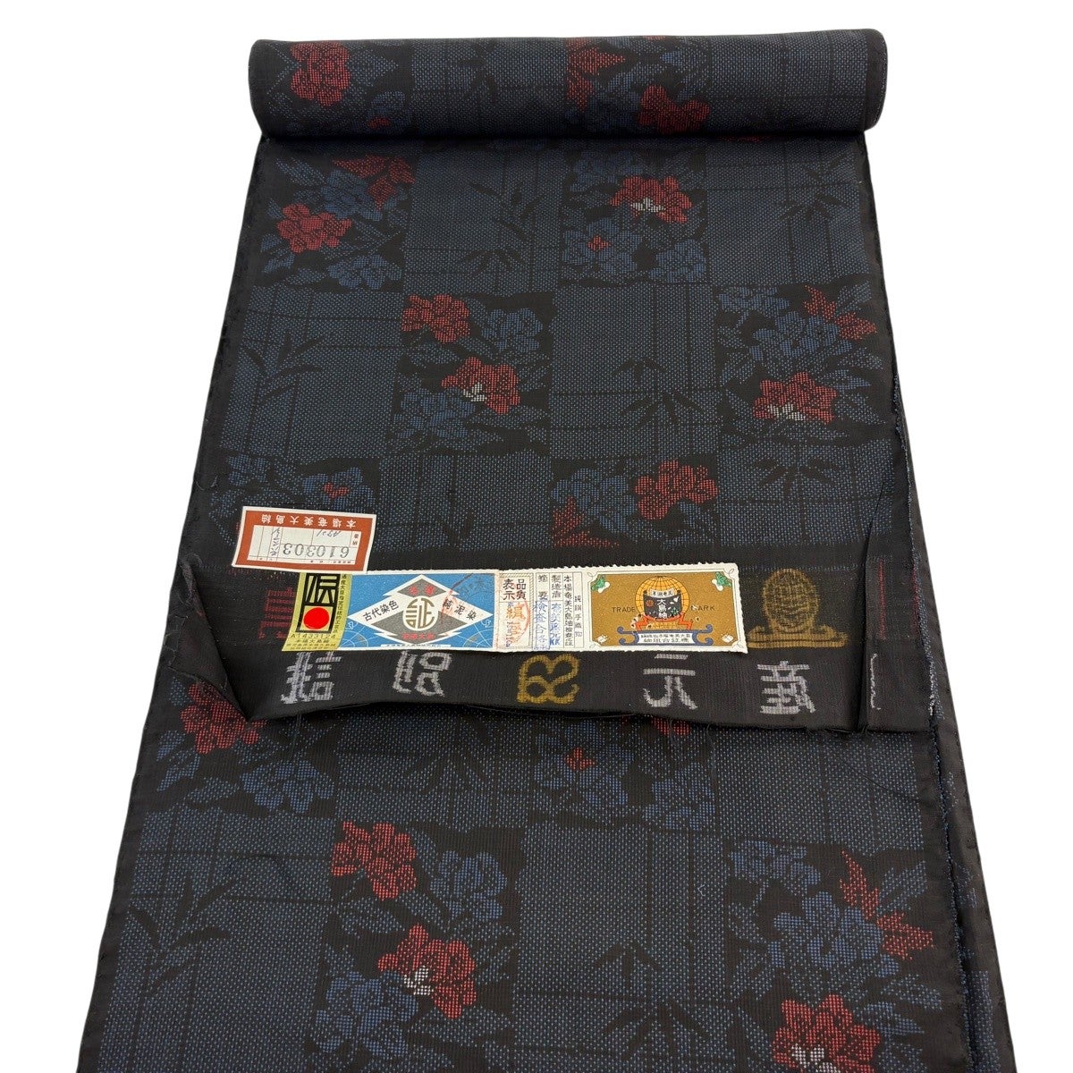 ［大島紬］新品未使用品　しつけ有り　証紙有り　裄丈70,5　K-302 反物 秀品 大島紬 証紙 純泥染 色紙 草花 紺色 正絹｜中古・古着